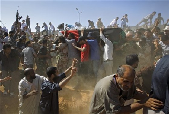 Libyan men carry the coffin, gesture and chant slogans during funeral of Libyan rebels' slain military chief Abdel-Fattah Younis in the rebel-held town of Benghazi, Libya, on July 29. Thousands of mourners marched in the funeral procession Friday for the Libyan rebels' slain military chief, a day after he was gunned down under still mysterious circumstances. Abdel-Fattah Younis was killed as he traveled from his front lines operations room to the rebels' de facto capital Benghazi.